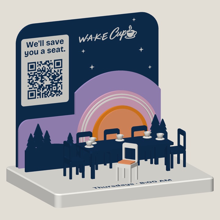 Large custom 3D-printed sign: the Wake Cup Connection table, a miniature meeting table with navy chairs and coffee cups in front of a layered sunrise, one white chair pulled out